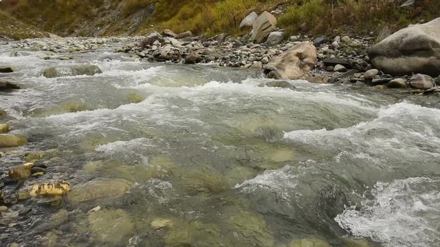 Amazing touristic place near river in mountain valley at the foot of Mt. Shkhara 5,193 m (17,040 ft). Upper Svaneti, Georgia, Europe. Caucasus mountains. HD video clip (High Definition).