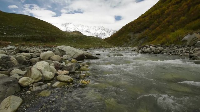 Amazing touristic place near river in mountain valley at the foot of Mt. Shkhara 5,193 m (17,040 ft). Upper Svaneti, Georgia, Europe. Caucasus mountains. HD video clip (High Definition).