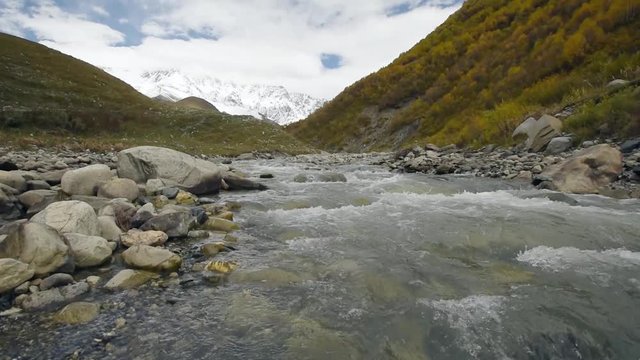 Amazing touristic place near river in mountain valley at the foot of Mt. Shkhara 5,193 m (17,040 ft). Upper Svaneti, Georgia, Europe. Caucasus mountains. HD video clip (High Definition).