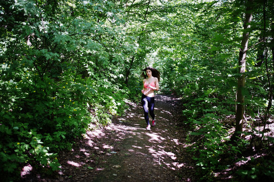 Fitness sport girl in sportswear running in forest, outdoor sports, urban style.