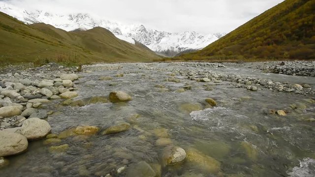 Amazing touristic place near river in mountain valley at the foot of Mt. Shkhara 5,193 m (17,040 ft). Upper Svaneti, Georgia, Europe. Caucasus mountains. HD video clip (High Definition).