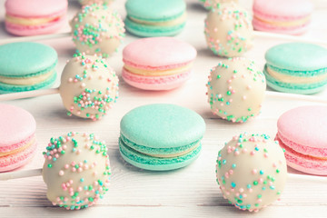 Sweet background of mint and strawberry flavor macaroons and cake pops on sticks