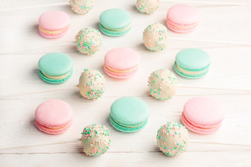 Fototapeta na wymiar Collection of colorful green and pink macaroons with cake pops on sticks on white background