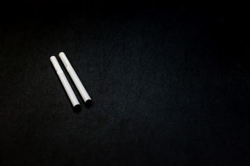 Naklejka premium Cigarettes closeup on a black background. Stop quit Smoking background. Concept Quitting smoking. World No Tobacco Day