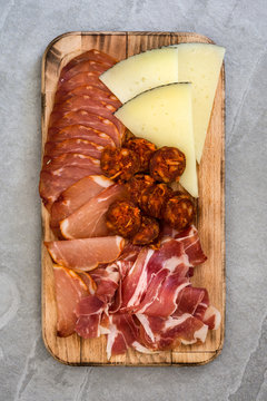 Spanish cold cuts (embutidos). Cheese, sausage and ham on gray table
