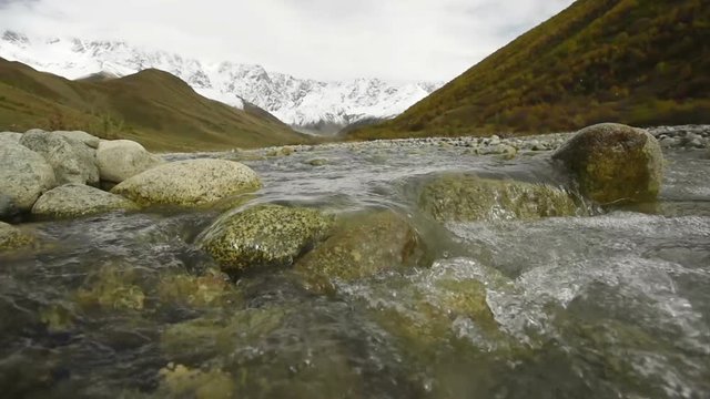 Amazing touristic place near river in mountain valley at the foot of Mt. Shkhara 5,193 m (17,040 ft). Upper Svaneti, Georgia, Europe. Caucasus mountains. HD video clip (High Definition).