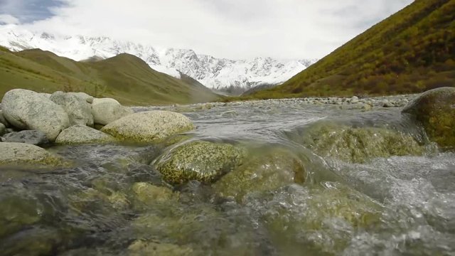 Amazing touristic place near river in mountain valley at the foot of Mt. Shkhara 5,193 m (17,040 ft). Upper Svaneti, Georgia, Europe. Caucasus mountains. HD video clip (High Definition).