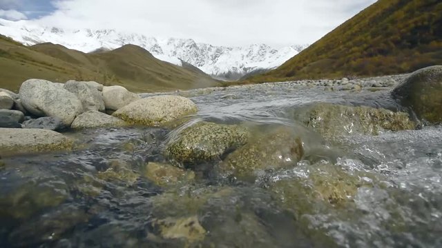 Amazing touristic place near river in mountain valley at the foot of Mt. Shkhara 5,193 m (17,040 ft). Upper Svaneti, Georgia, Europe. Caucasus mountains. HD video clip (High Definition).