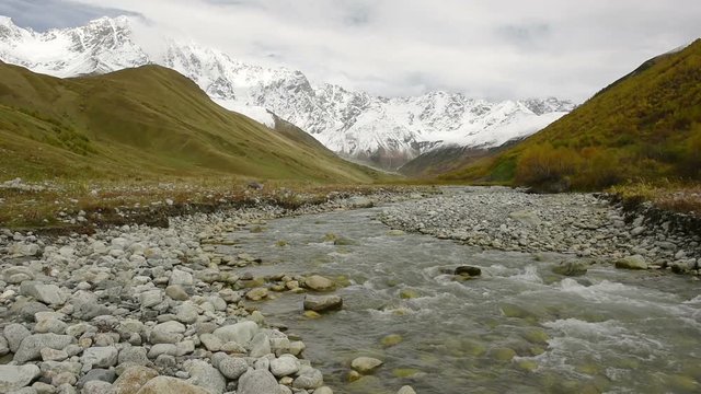 Amazing touristic place near river in mountain valley at the foot of Mt. Shkhara 5,193 m (17,040 ft). Upper Svaneti, Georgia, Europe. Caucasus mountains. HD video clip (High Definition).