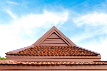 Fototapeta na wymiar detail of wooden roof gable with clay roof tile on blue sky