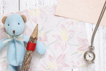 Flat lay stock photography flower pattern message letter paper blue bear holding wood pencil pocket clock