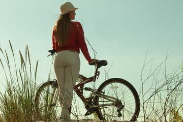 Unrecognizable woman bike cycling on sand