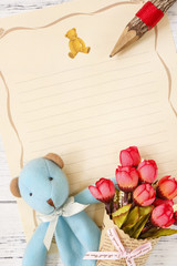 Flat lay stock photography flower letter paper blue bear doll holding rose wood pencil