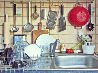 parade of useful kitchen tools, rolling pin, ladles,stainers,rasps,colenders and tableware hanging...