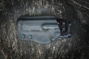 Handmade kydex holster for pistol on a grungy wood table