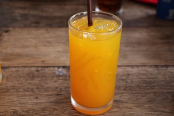 Orange juice in glass with plastic tube