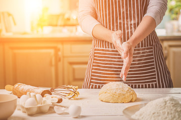 Woman slap his hands above dough closeup. Baker finishing his bakery, shake flour from his hands, free space for text.