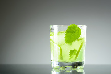 A glass of Mojito with ice, lime wedges and mint