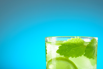 A glass of Mojito with ice, lime wedges and mint