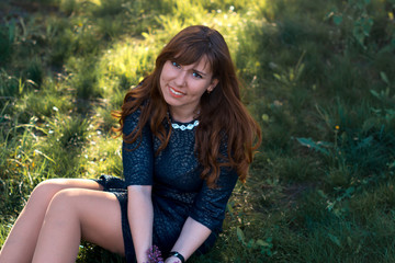 Young girl in the spring evening in a park with lilac flowers.