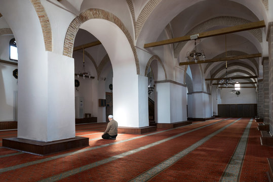 Muslims praying alone in mosque