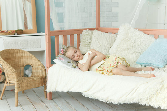 Little Girl Sleeping Hugging A Book