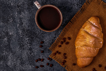 Fresh croissant on dark background.