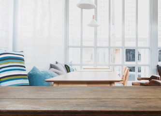 Obraz premium Wood table top and blurred bokeh cafe and coffee shop interior background with vintage filter - can used for display or montage your products.