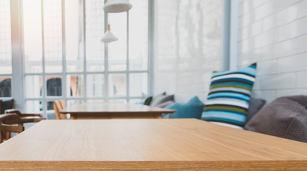 Wood table top and blurred bokeh cafe and coffee shop interior background with vintage filter - can used for display or montage your products.