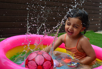 A girl enjoying in a water pool on a hot summer day!