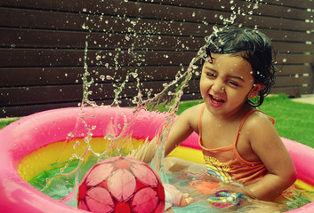A girl enjoying in a water pool on a hot summer day!