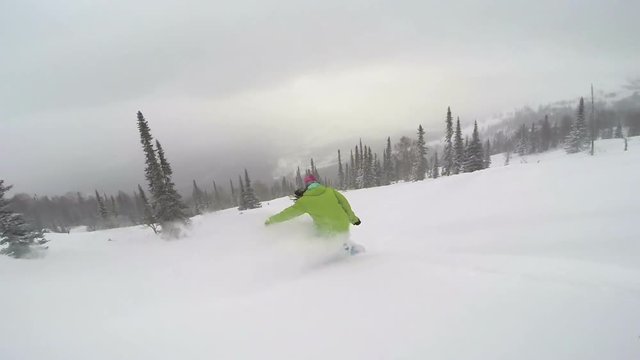 Snowboarder girl rides in powder snow