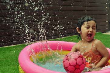 A girl enjoying in a water pool on a hot summer day!