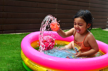 A girl enjoying in a water pool on a hot summer day!