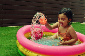 A girl enjoying in a water pool on a hot summer day!