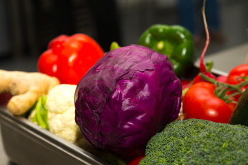 Set of fresh vegetables and herbs on a metal table of restaurant kitchen. Selective focus. Shallow depth of field