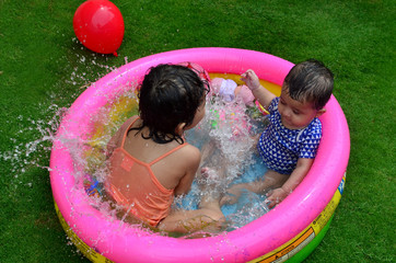 Sisters playing and enjoying in a small swimming pool