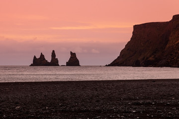 Rock Troll's fingers in the ocean near the beach with black sand in Vik, south of Iceland