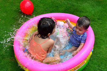 Sisters playing and enjoying in a small swimming pool