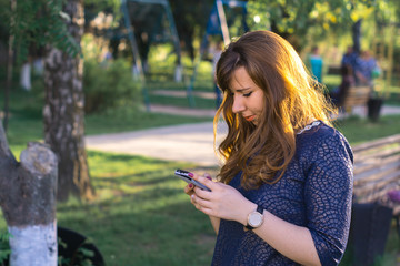 Girl in the park with a mobile phone.