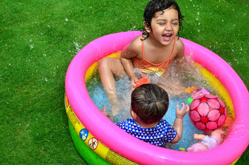 Sisters playing and enjoying in a small swimming pool