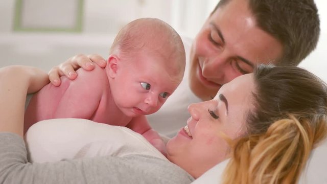 Happy young family. Father, mother and their newborn baby. Parenthood concept. 3840X2160 4K UHD video