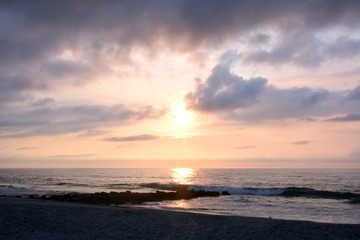 Glowing and Golden Summer Sunrise at the Shore Over Rock Jetty