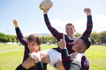 Portrait of happy rugby players enjoying at field 