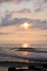 Obraz premium Heavenly Summer Seashore Sunrise Over Rock Jetty on the Beach