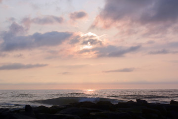 Obraz premium Heavenly Summer Seashore Sunrise Over Rock Jetty on the Beach