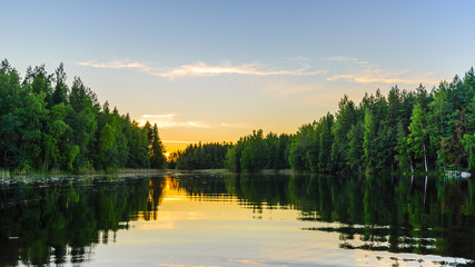 Lake at sunset with reflection of trees in the water.