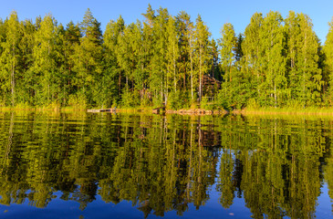 The shore of the lake is mirrored in the water.