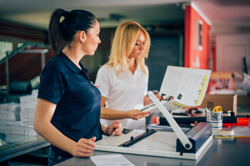 Two young woman working in printing factory