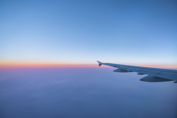 Naklejka na ściany i meble Airplane wing in the sky with morning light